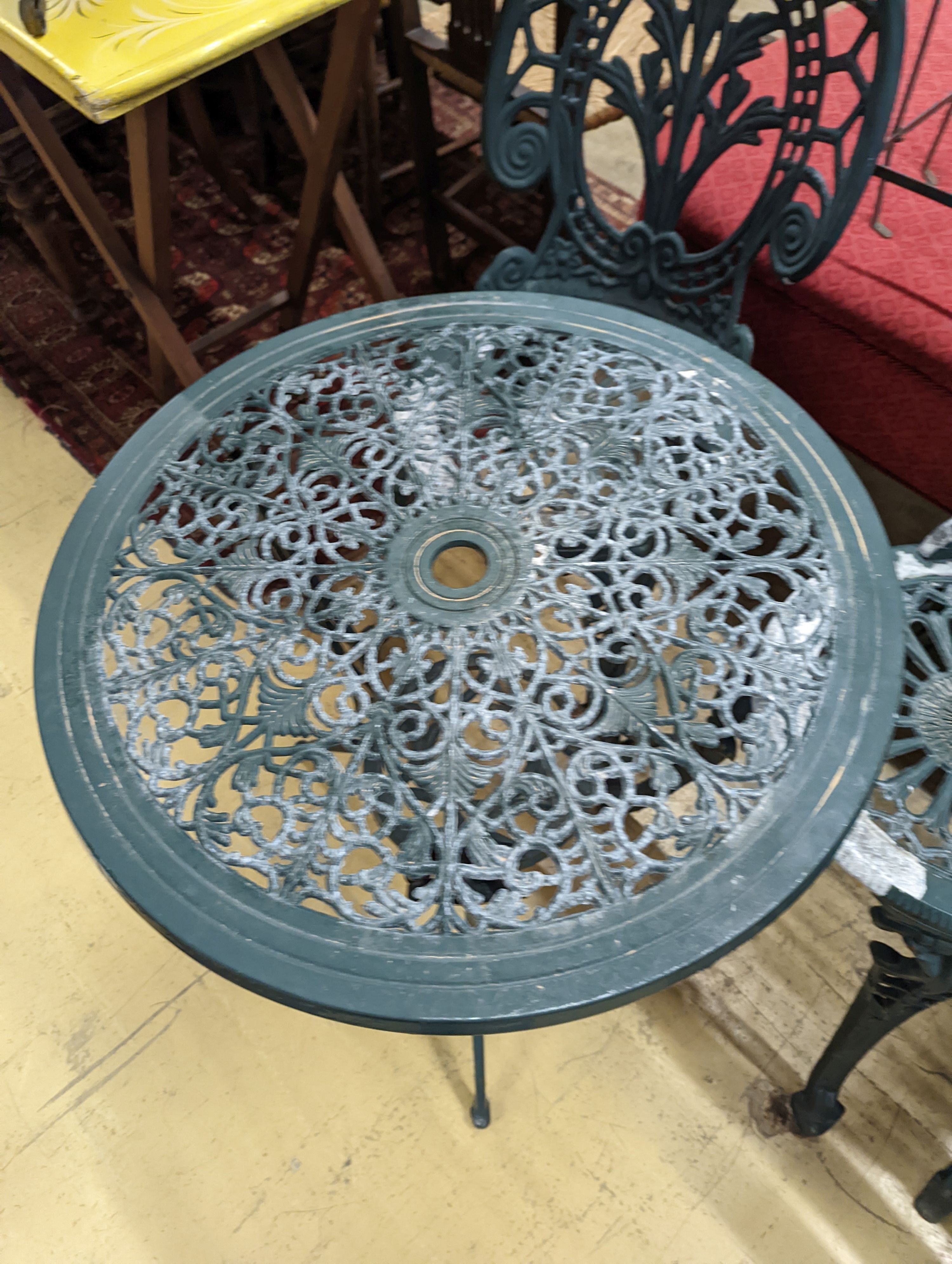 A circular painted aluminium garden table, diameter 60cm, height 62cm together with two chairs